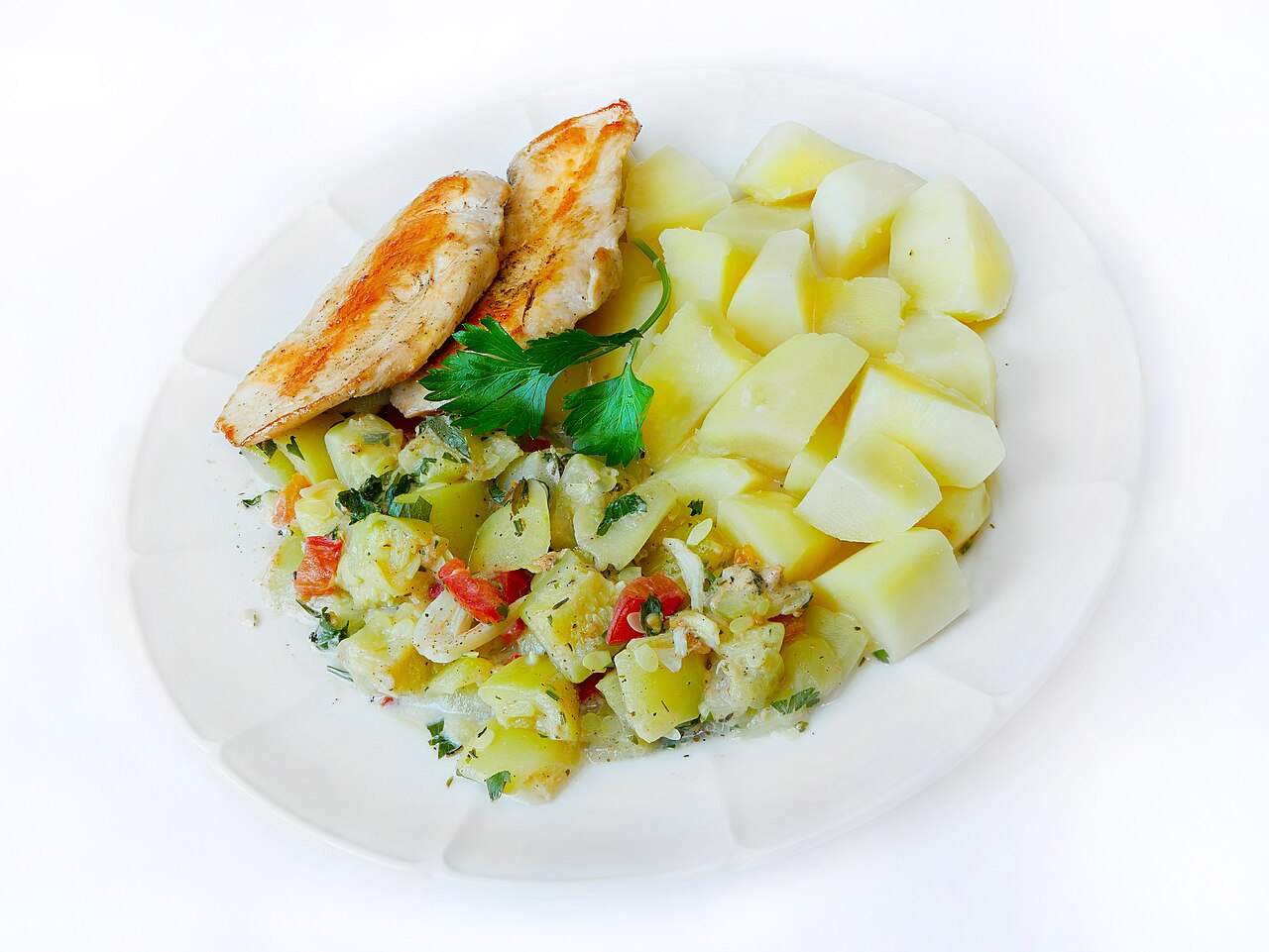 A plated lunch of pumpkin-sauce pasta with potatoes and chicken